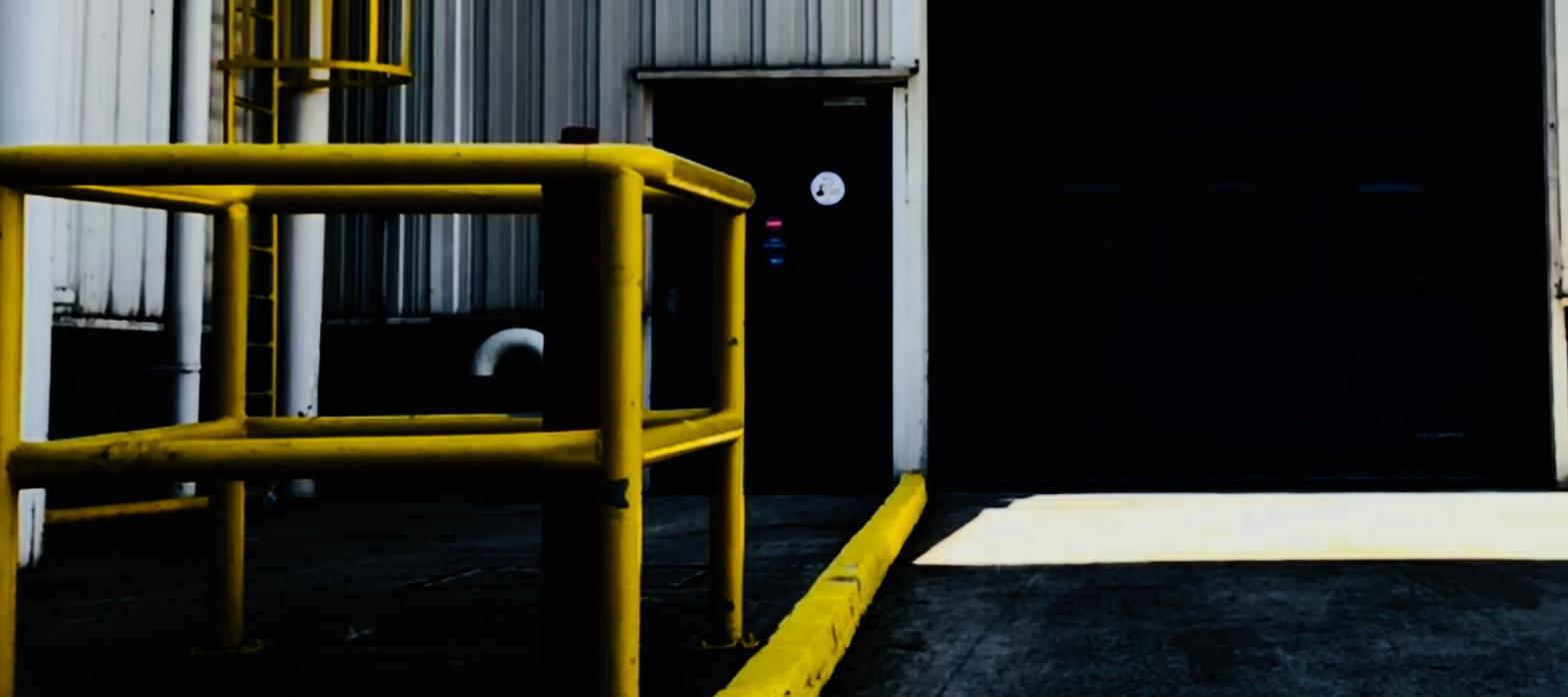Industrial loading dock with yellow safety railings, representing office and warehouse space heading to market.