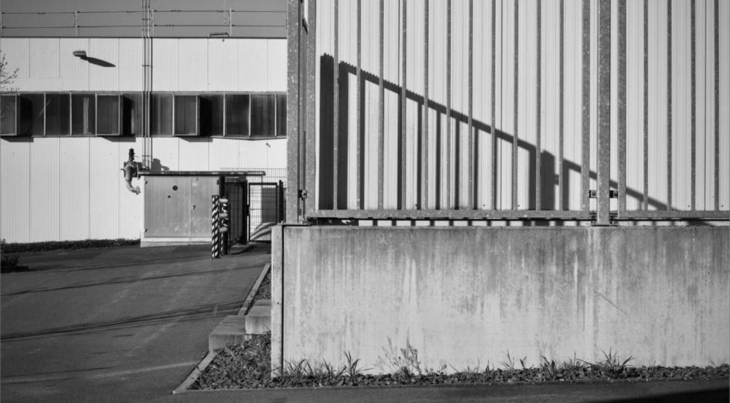 Gated industrial facility exterior with corrugated metal siding, representing the Byberry East Industrial Park.