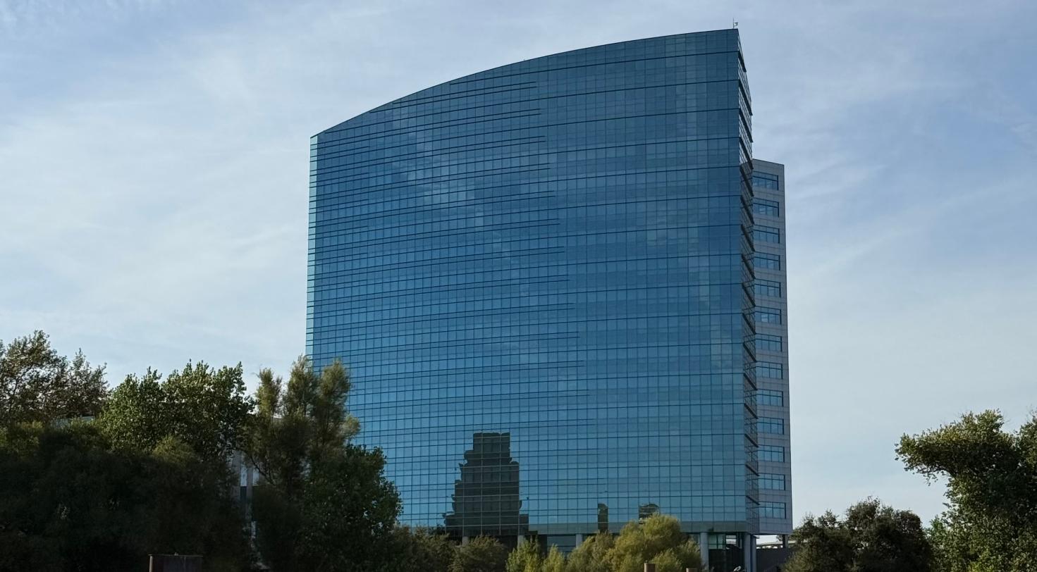 Modern glass building overlooking a riverside, representing a lab and innovation complex along the Schuylkill River.