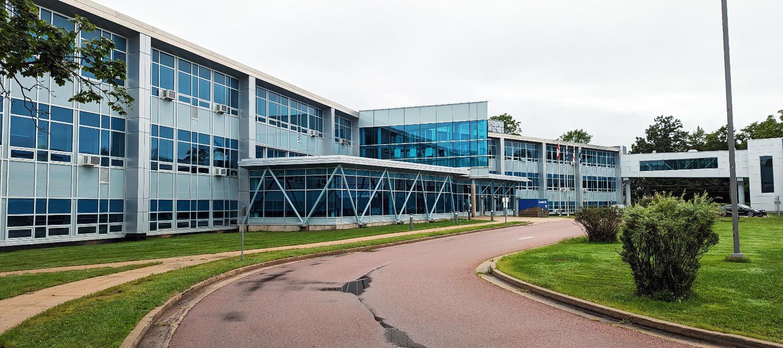 Modern institutional building exterior with glass curtain wall and landscaped entrance drive, representing a planned workforce development center.